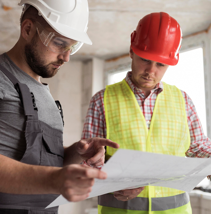 Construction workers reviewing blueprints